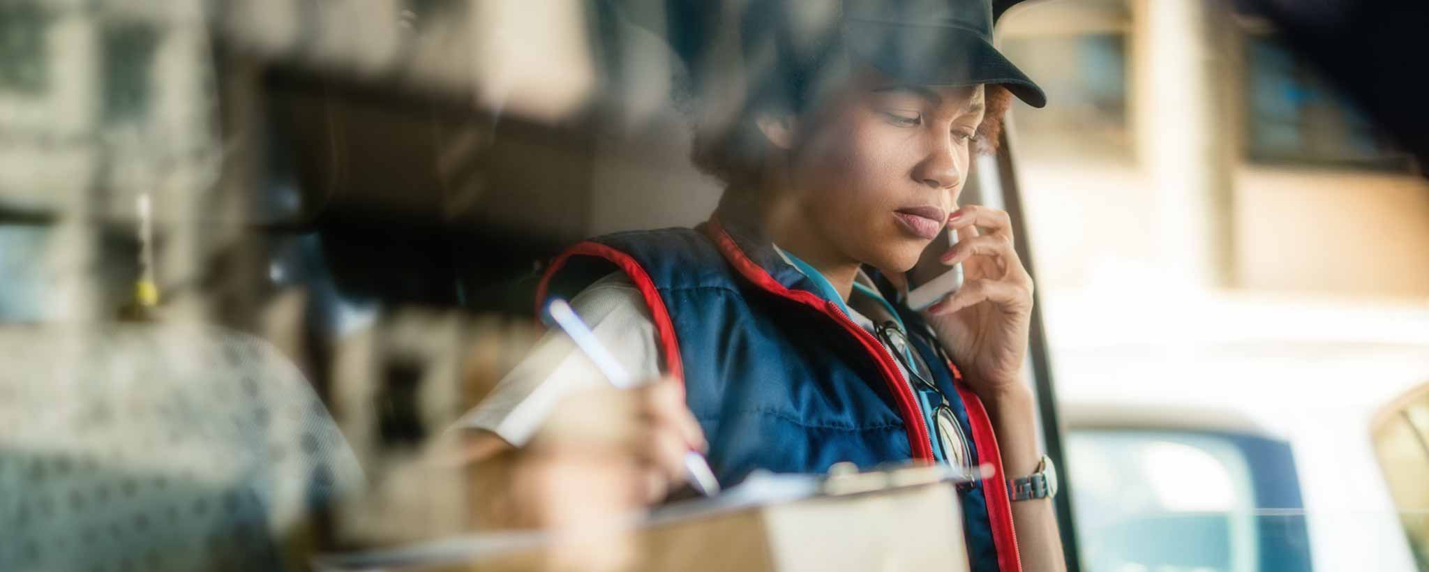 'An African-American postal worker in her truck.'