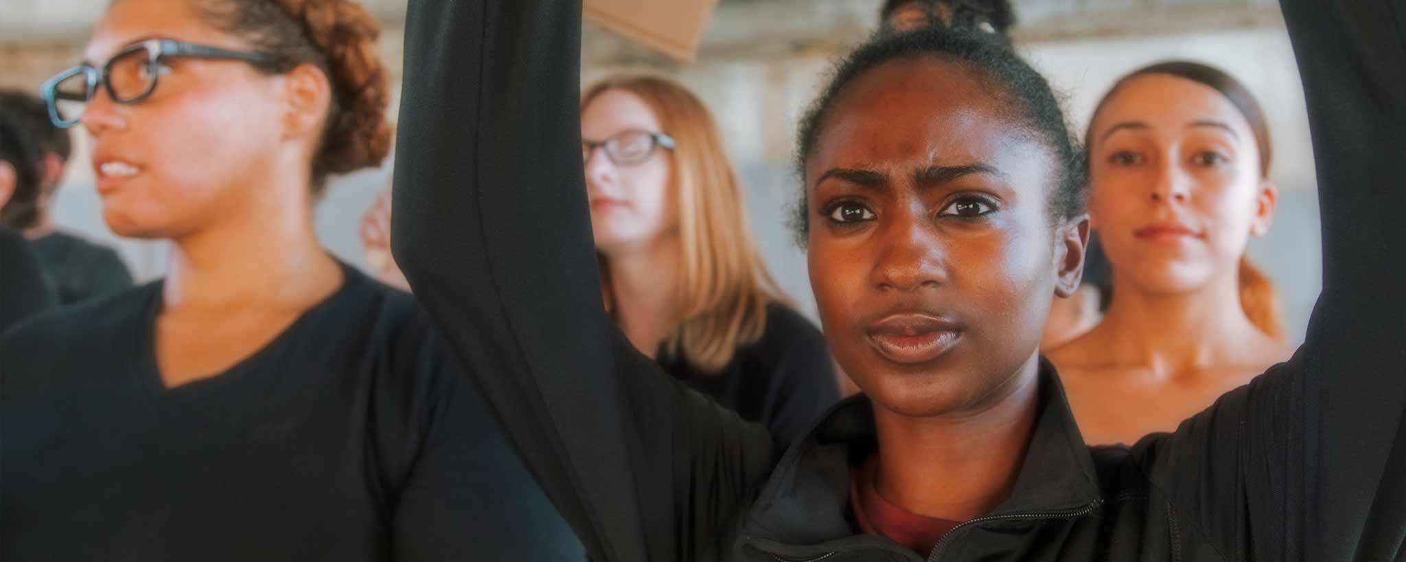 'A crowd of women wearing black shirts was their arms in protest.'