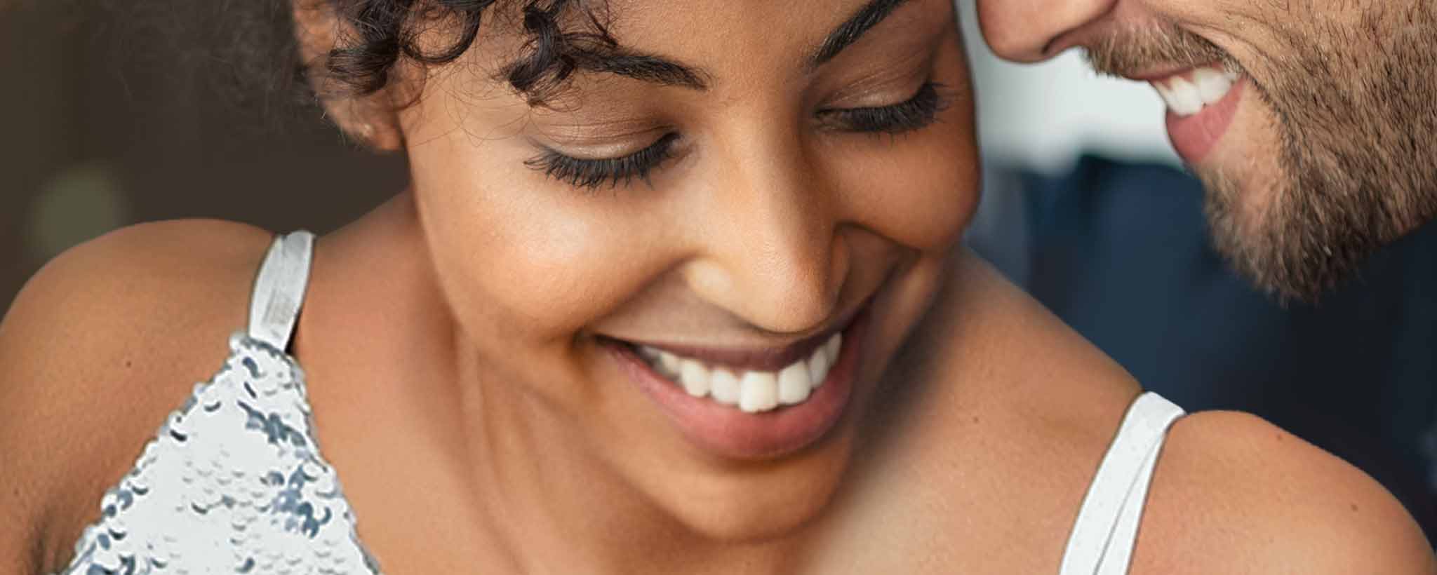 'The smiling faces of a biracial couple.'