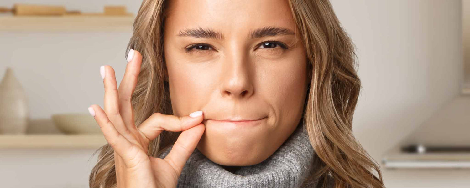 A blonde female zipping her lips.