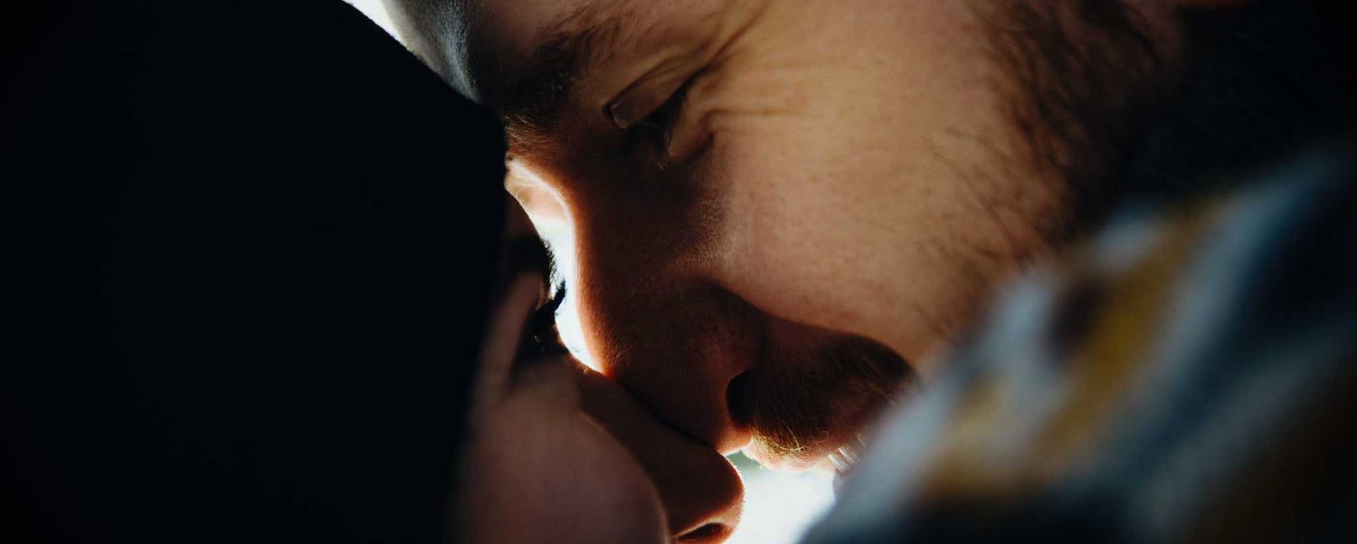Close-up of a man and a lady with their heads close together, in a romantic or intimate moment.