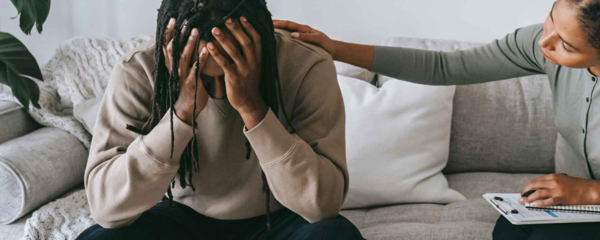 'A therapist comforts a black male patient.'