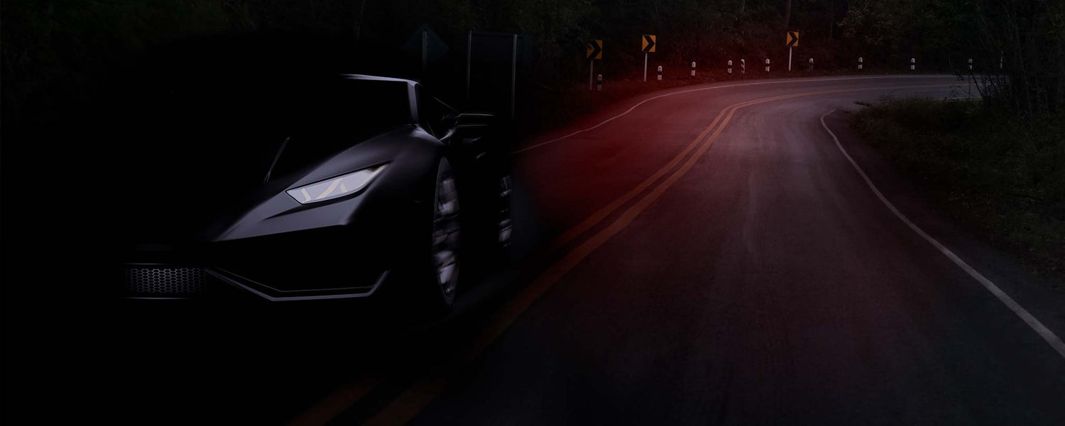 A black sports car driving on dark road.