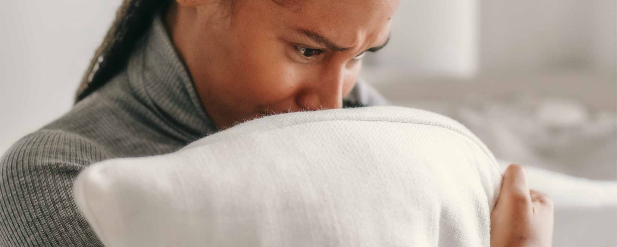 'A lonely female cries into her pillow.'