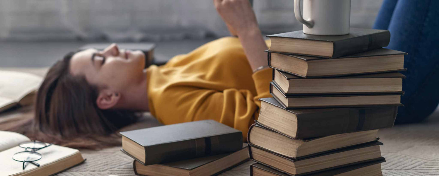 Woman lying on floor with books
