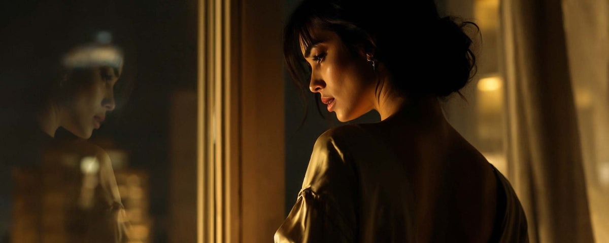 A female peers through a window at night skyline. (ai)
