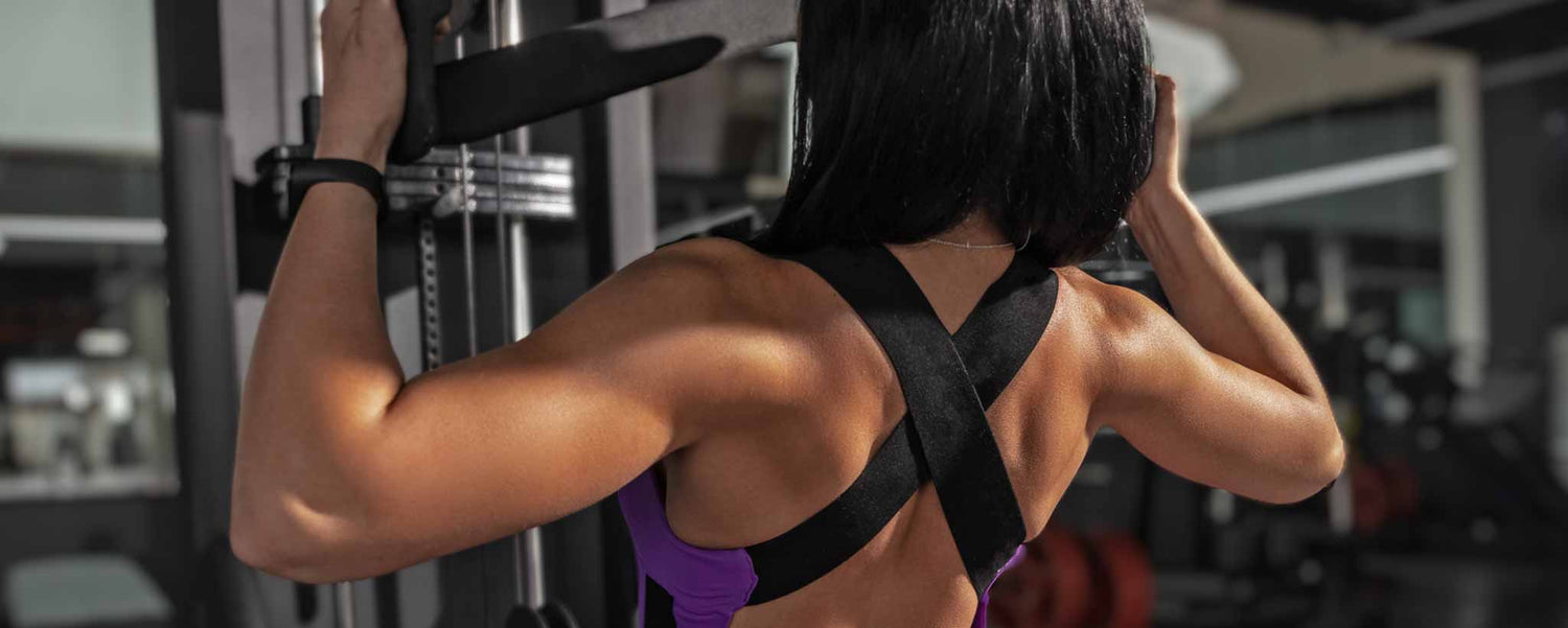 A female bodybuilder developed upper body strength with gym equipment.