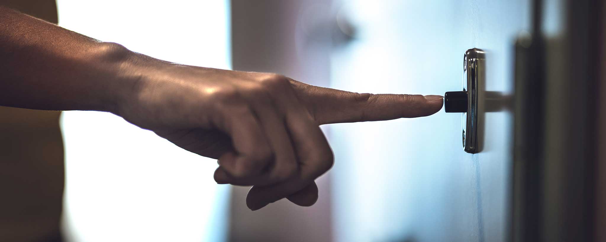'A finger pressing a doorbell.'