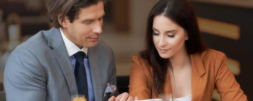 'A married couple in business attire has dinner at home.'