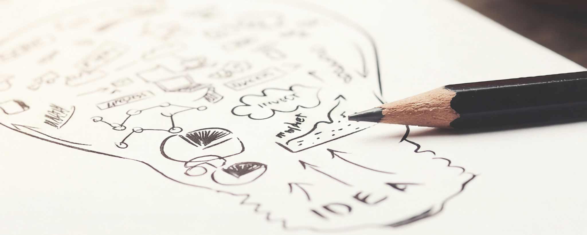 'Pencil on a piece of paper with hand-drawn illustrations and the word 'IDEA'.'
