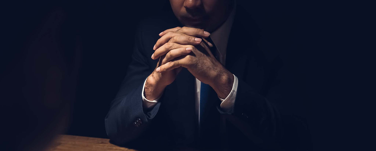 Interrogator with hands folded