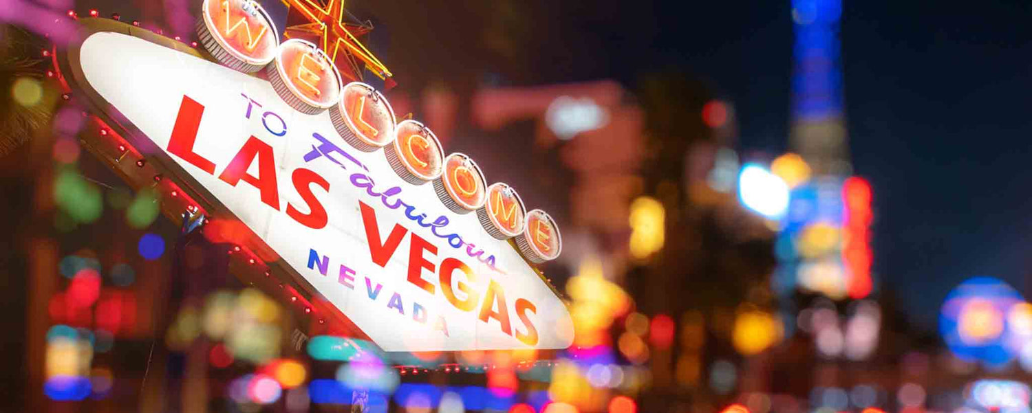 Colorful nighttime Las Vegas lights and welcome sign.