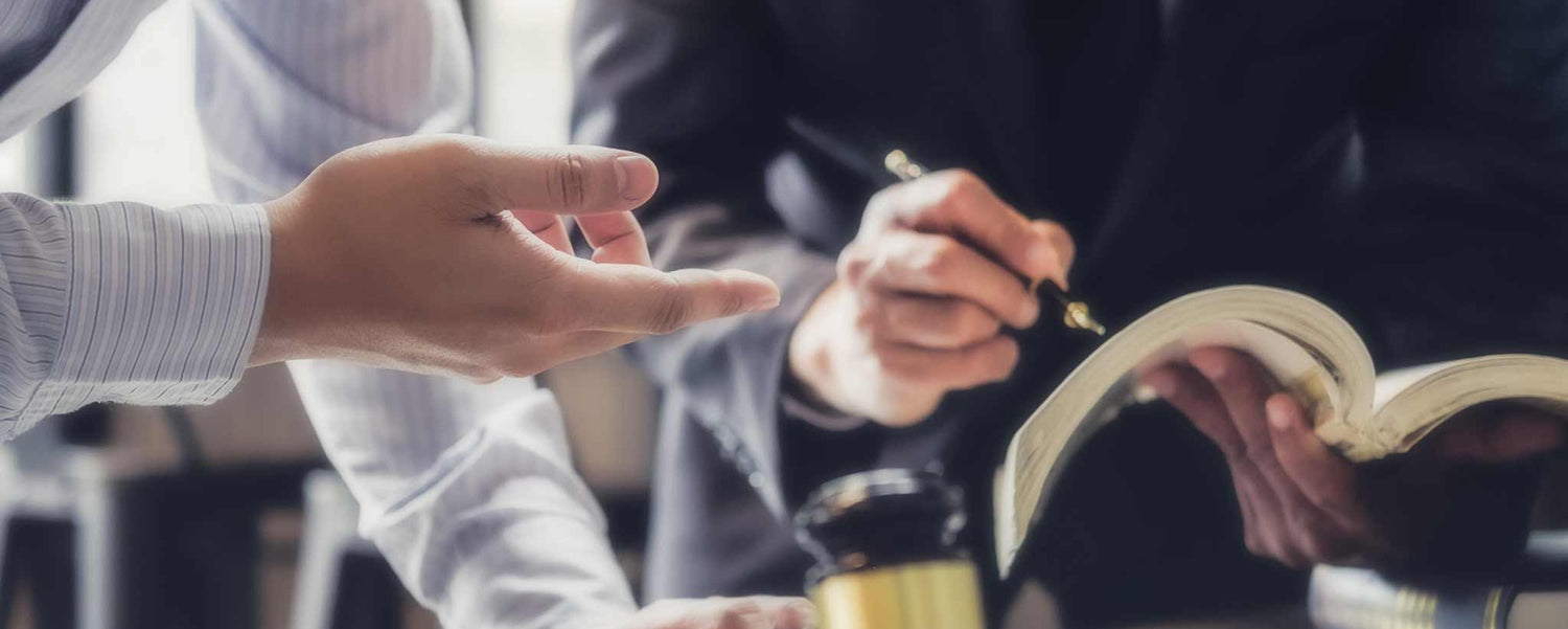 Men's hands review legal documents.