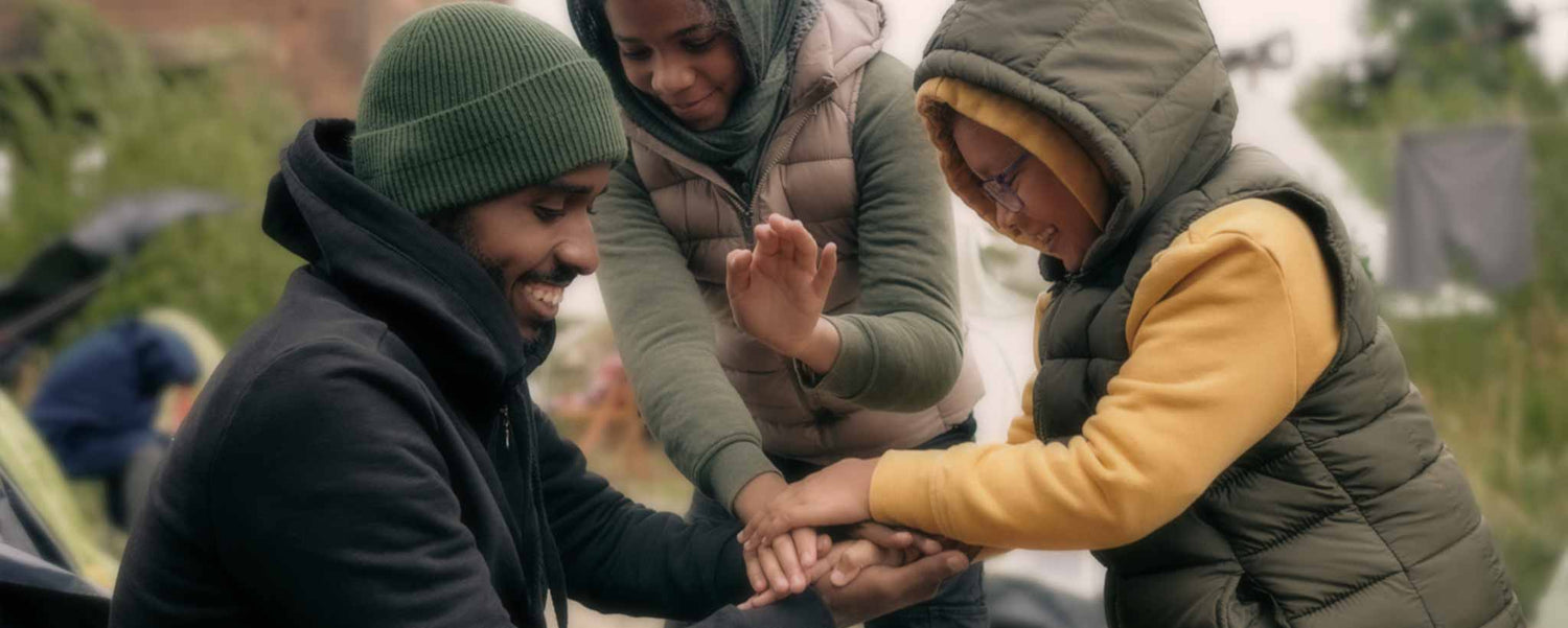 A Black man plays with homeless children.