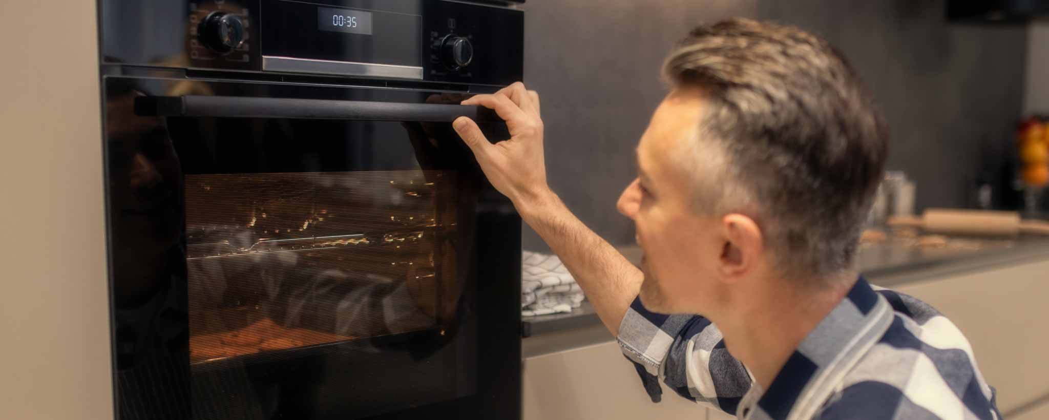 'Man watching food cook in oven'