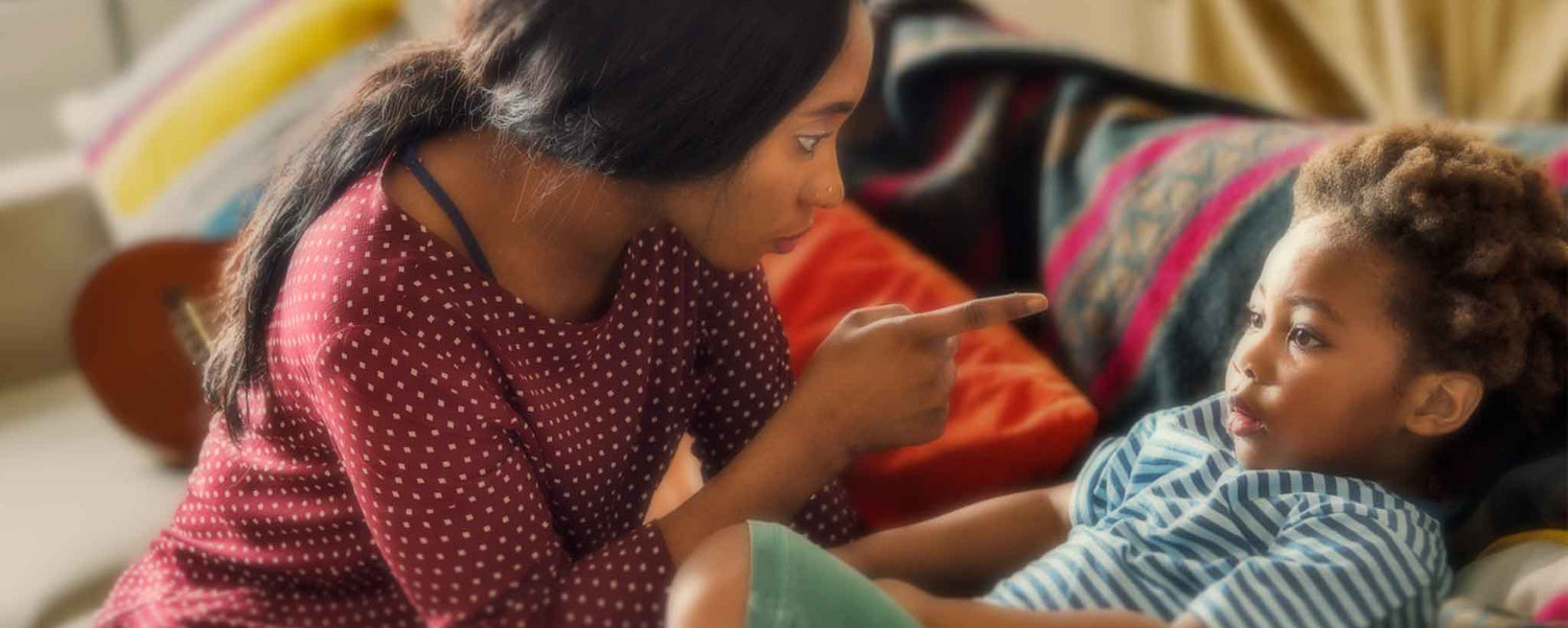 With her finer pointing, a black mother scolds her small child.