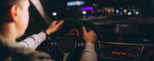 The nighttime car interior with man driving.