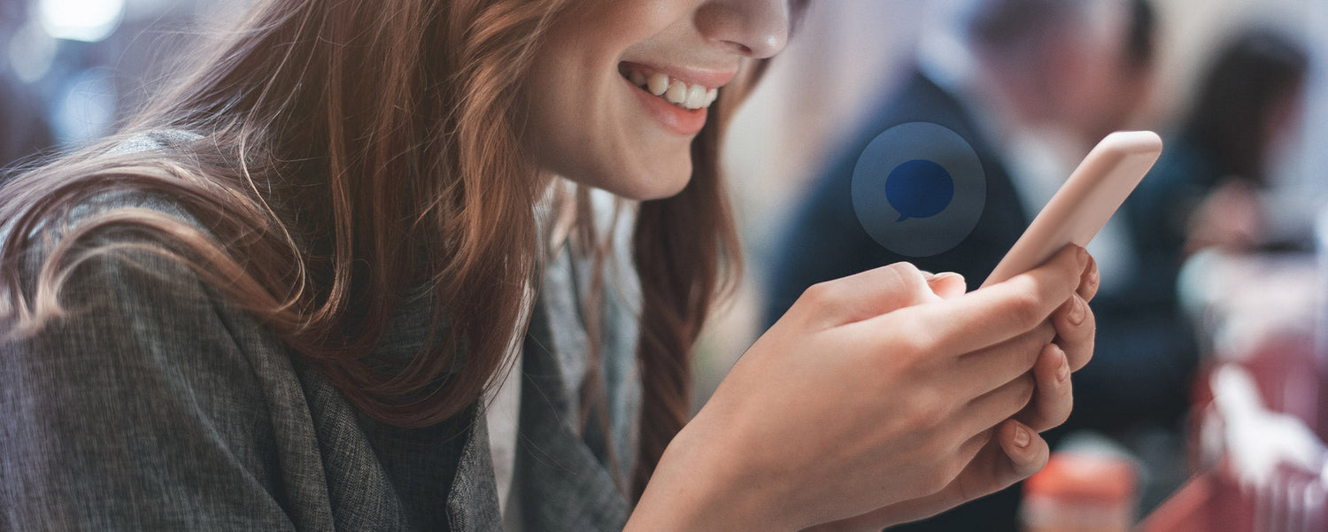 A smiling lady viewing her phone.