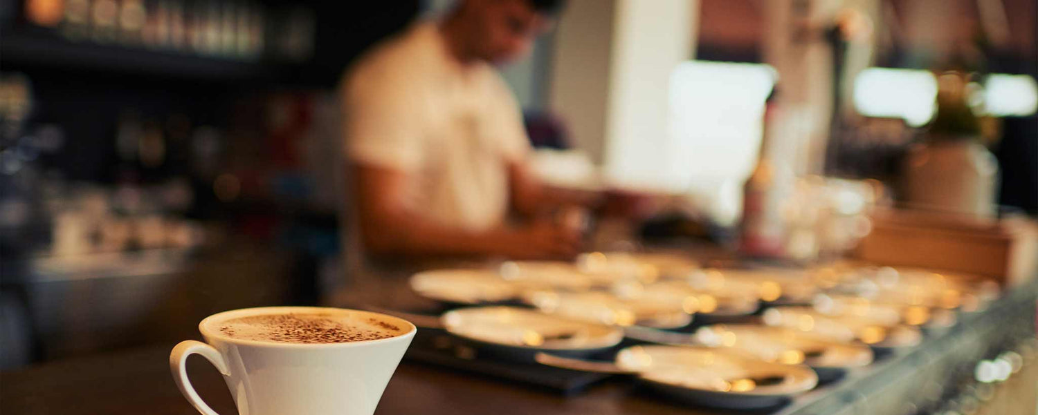 Rows of plates wait on a restaurant counter.
