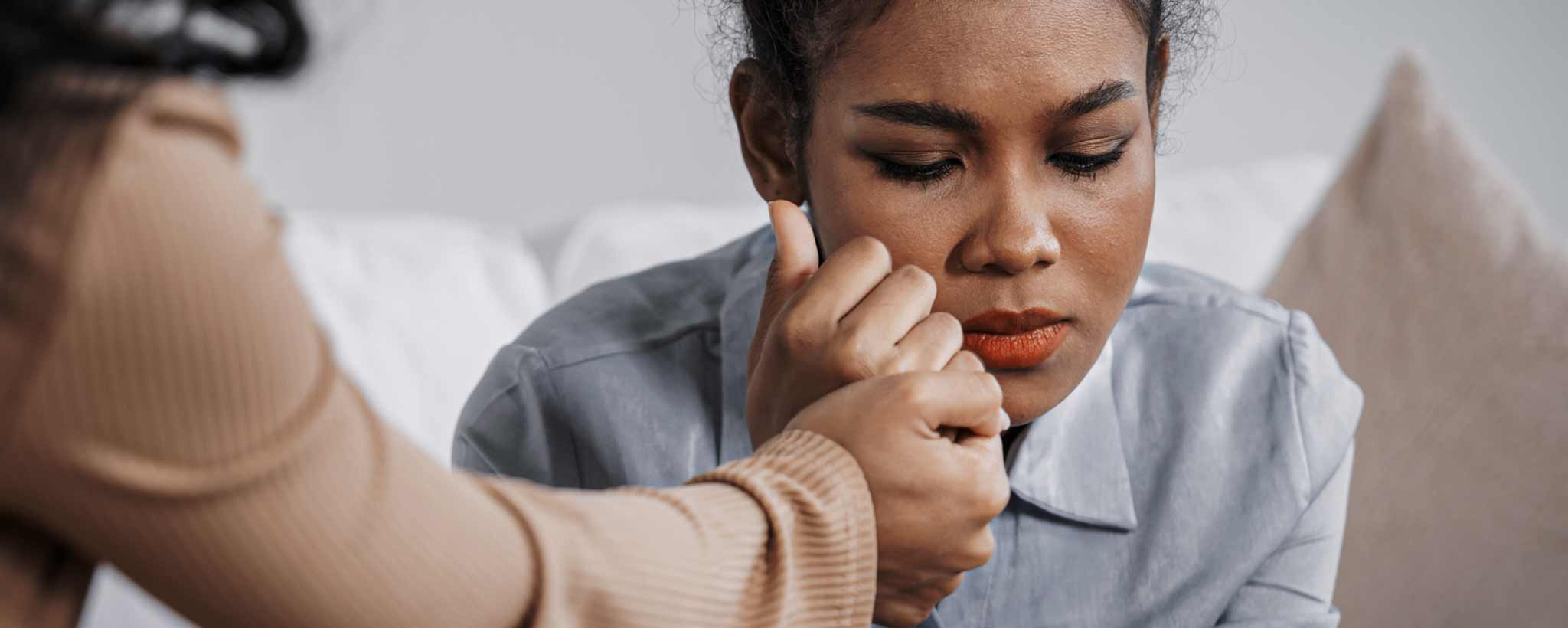 'A sad black female receiving supportive counseling.'
