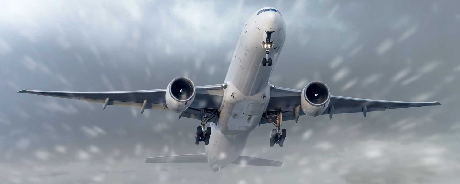 A commercial jet ascends through a snow storm.