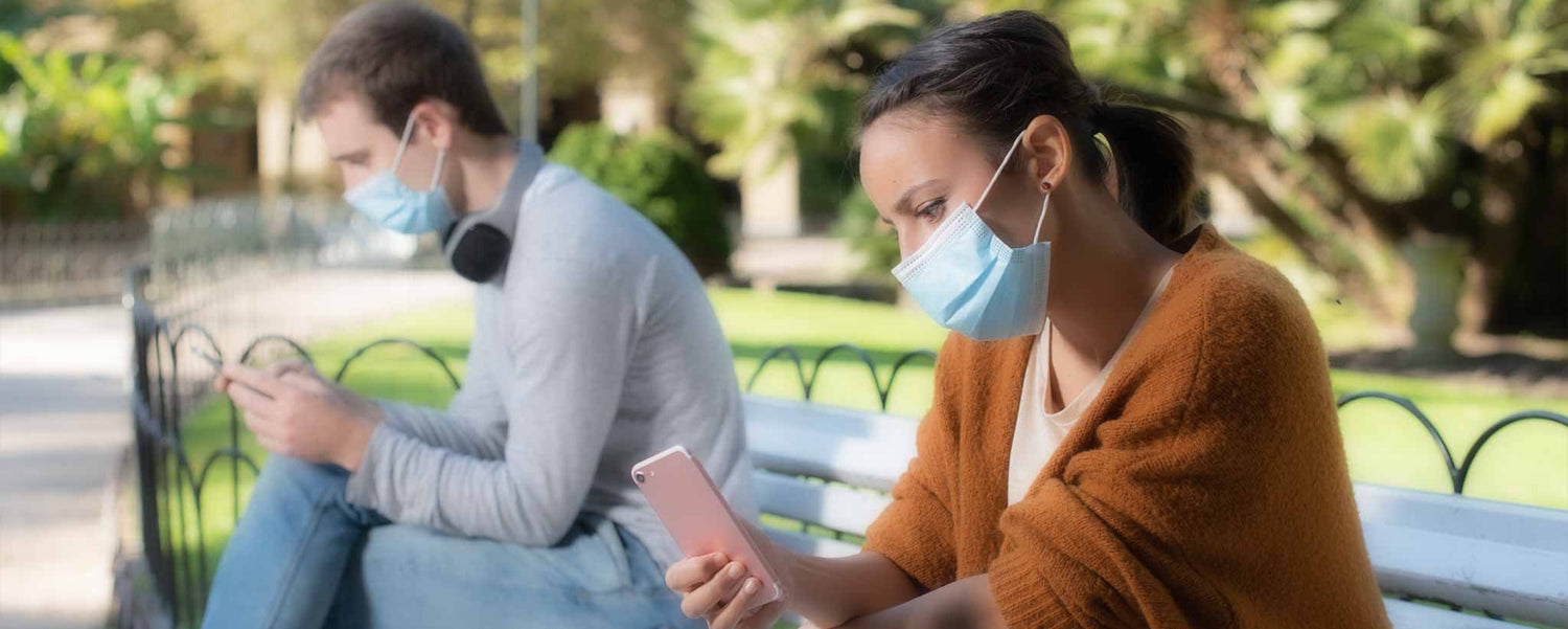 Man and woman social distance on park bench