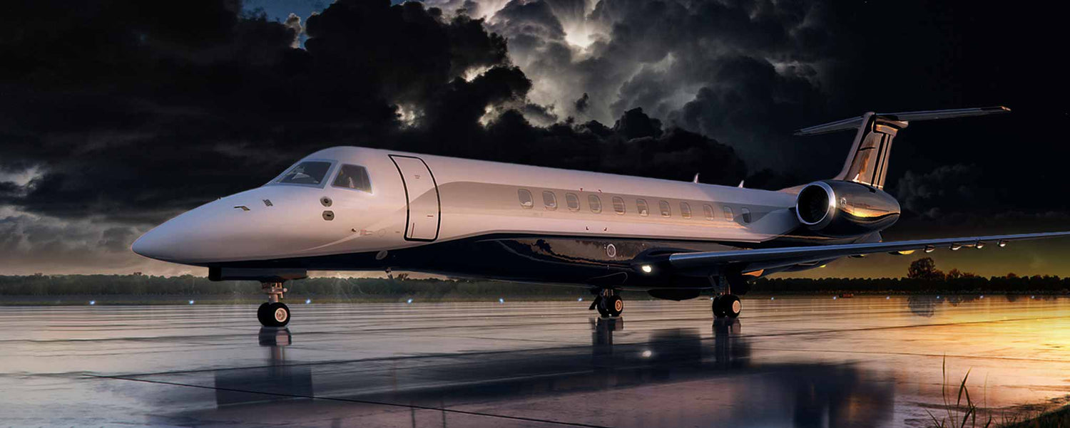 A Legacy 650E aircraft on a runway at night.