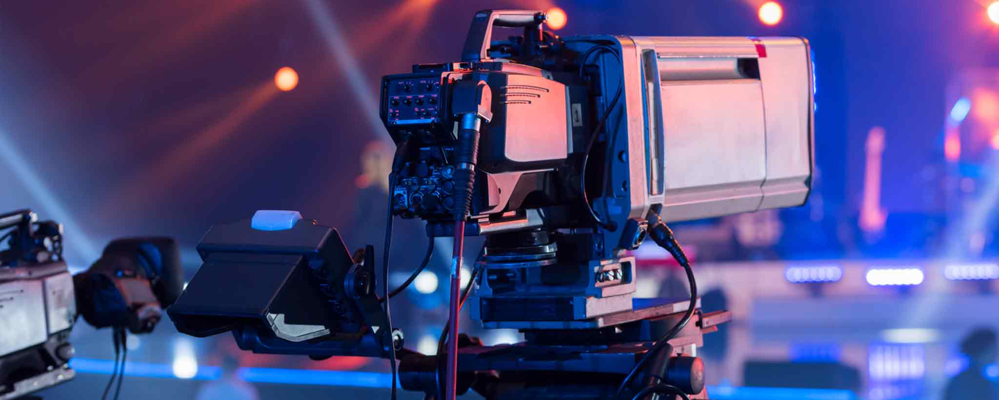 'A television camera aimed at a stage.'