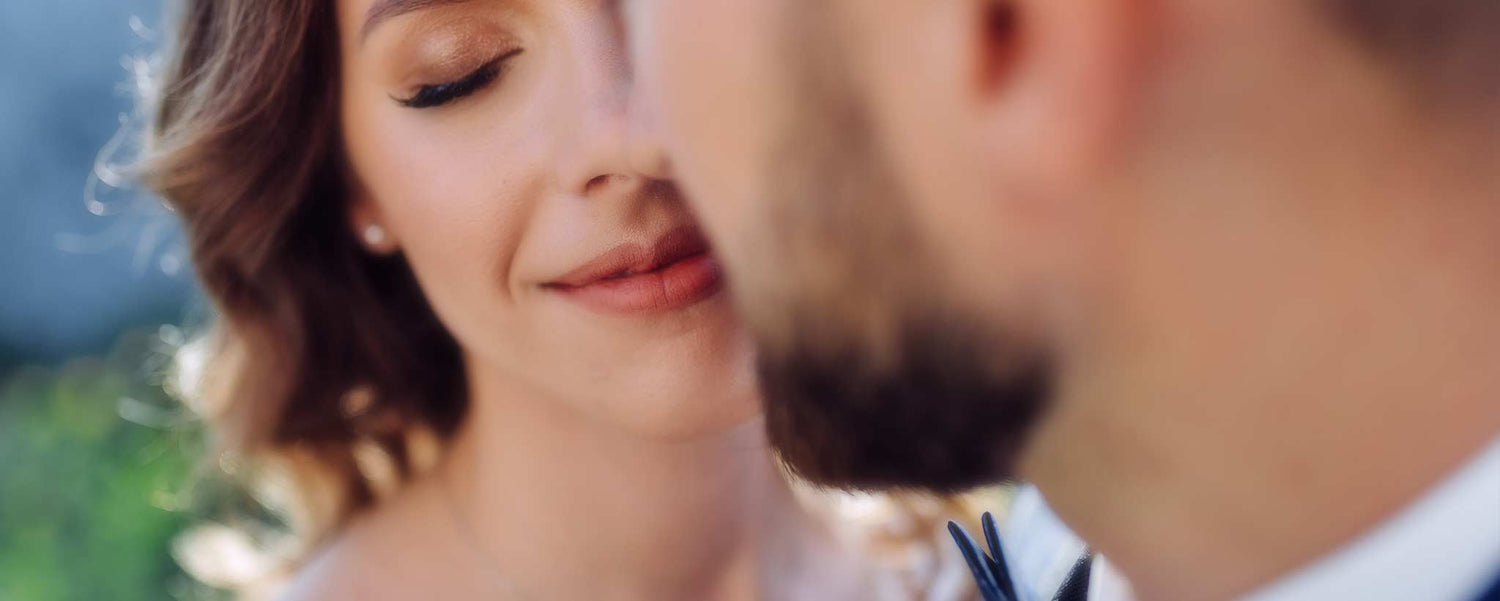 A wedding couple prepare to kiss.
