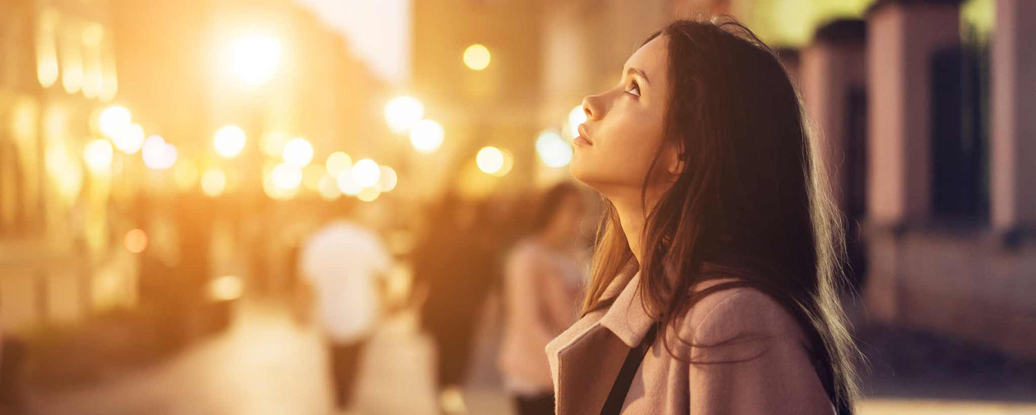 An ambitious lady looking up in a city. (ai)