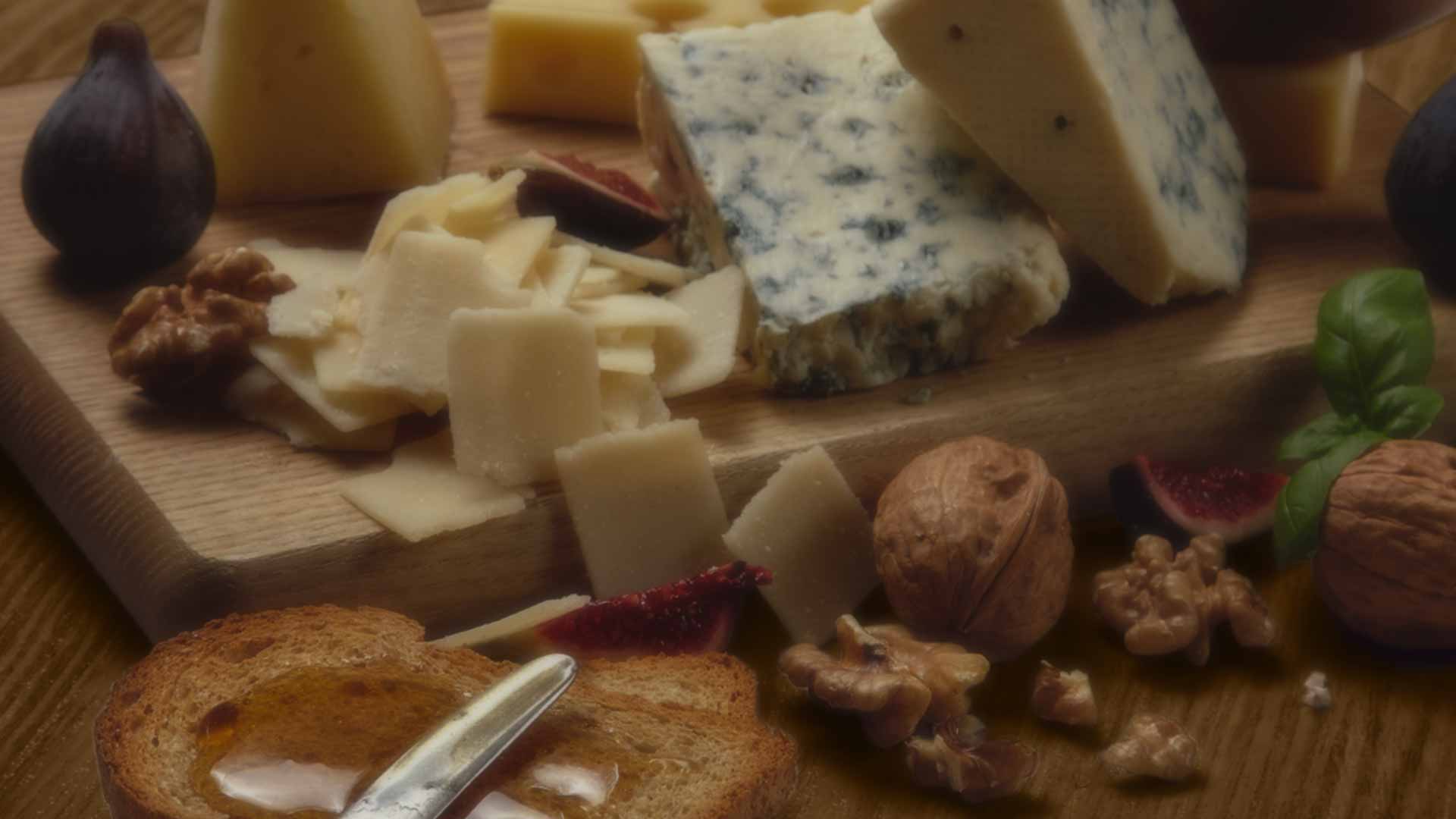 Cheeses, walnuts, figs on cutting board
