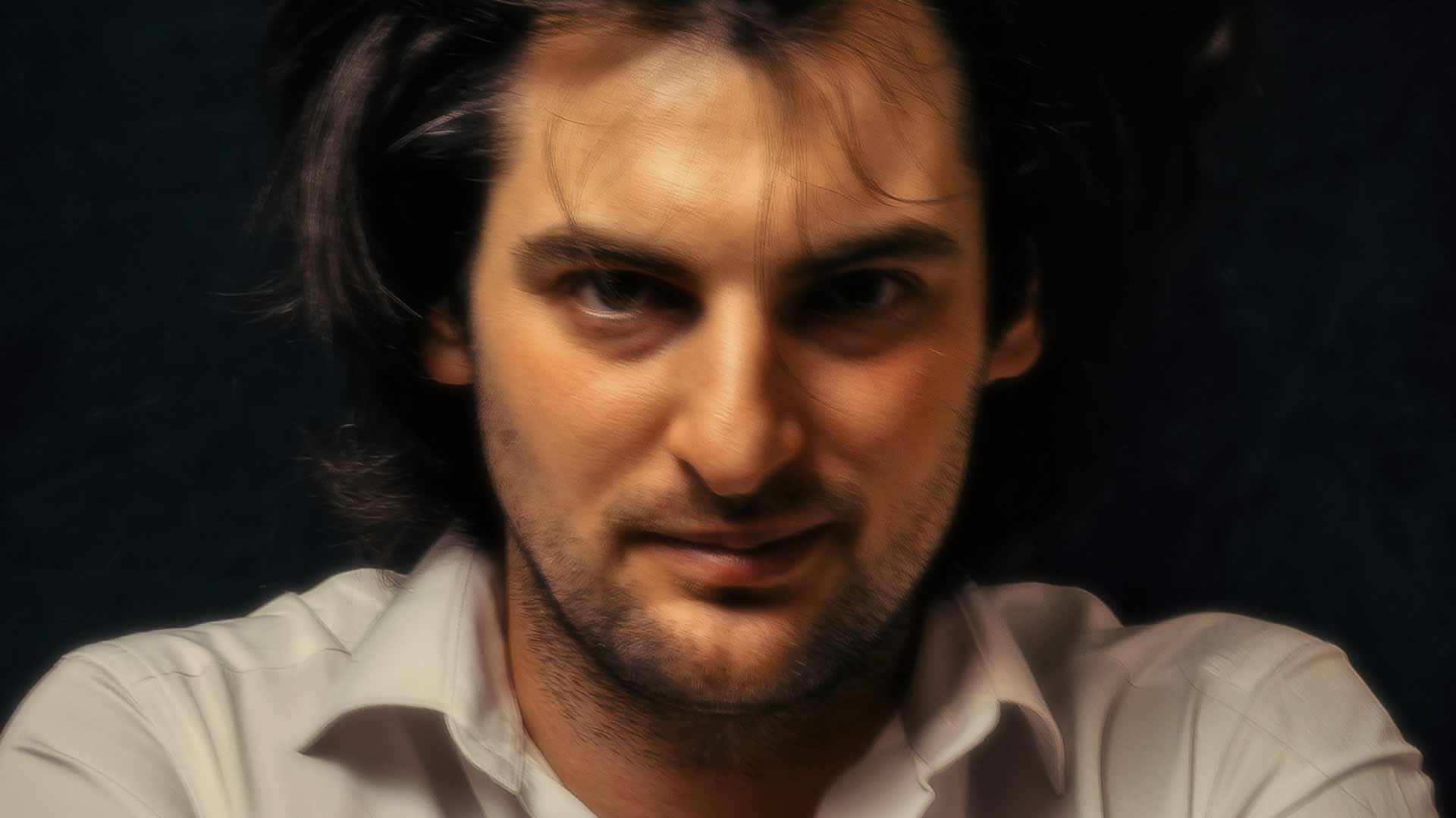 Bearded man with wild eyes staring at viewer