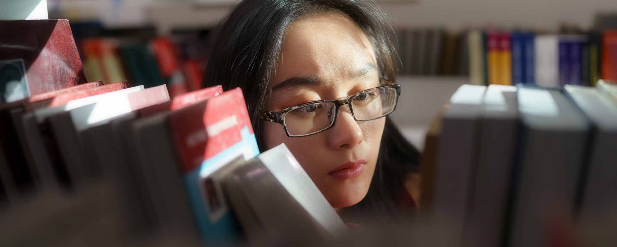 'Female looking through library books'
