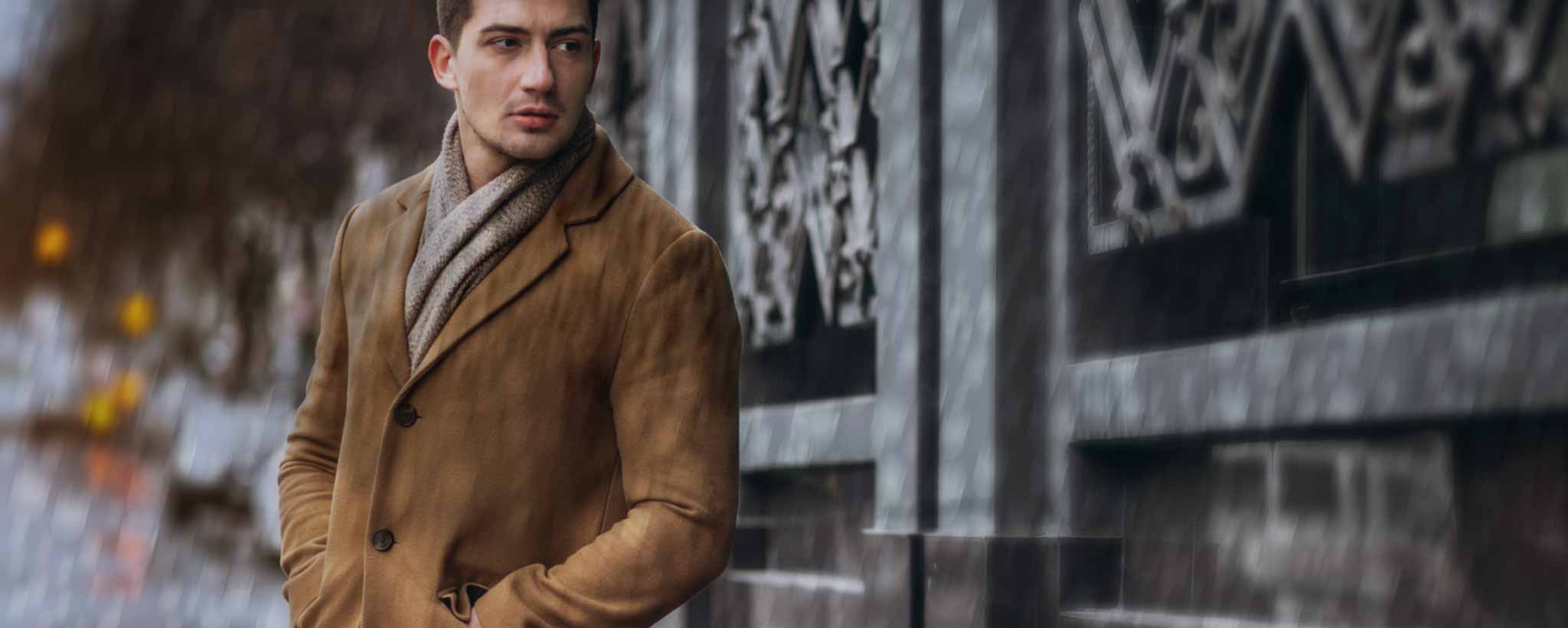 'A man wears a wet cashmere overcoat in the rain.'
