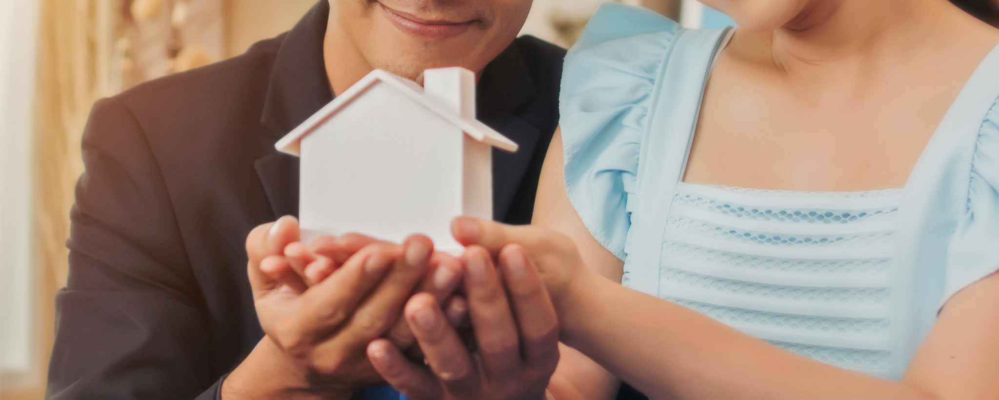 'Couple holding white tiny house'