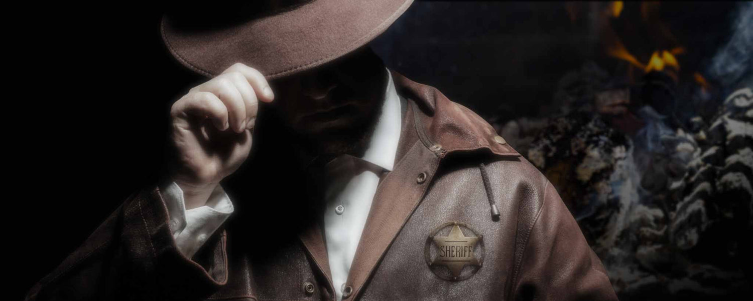 Sheriff in front of ashes tips his hat.