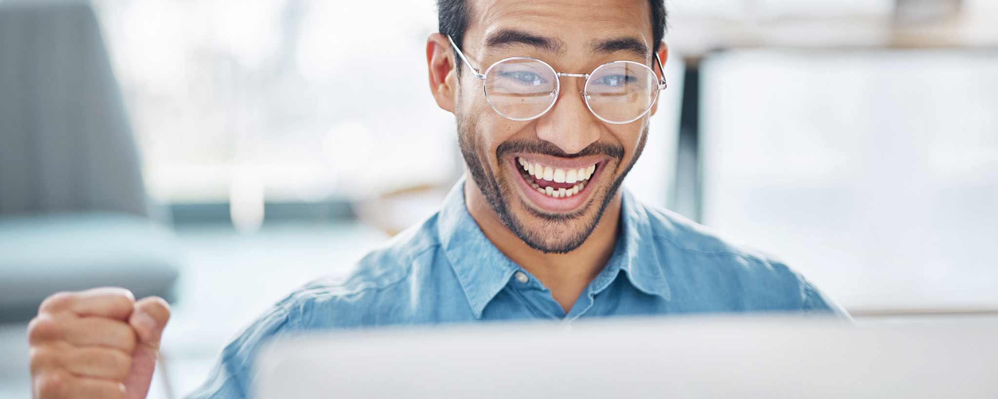 'Excited man sitting at computer'