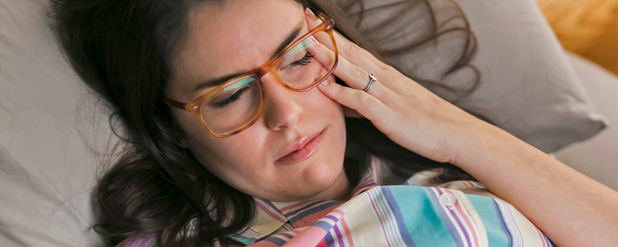 'Female lying in bed with headache'