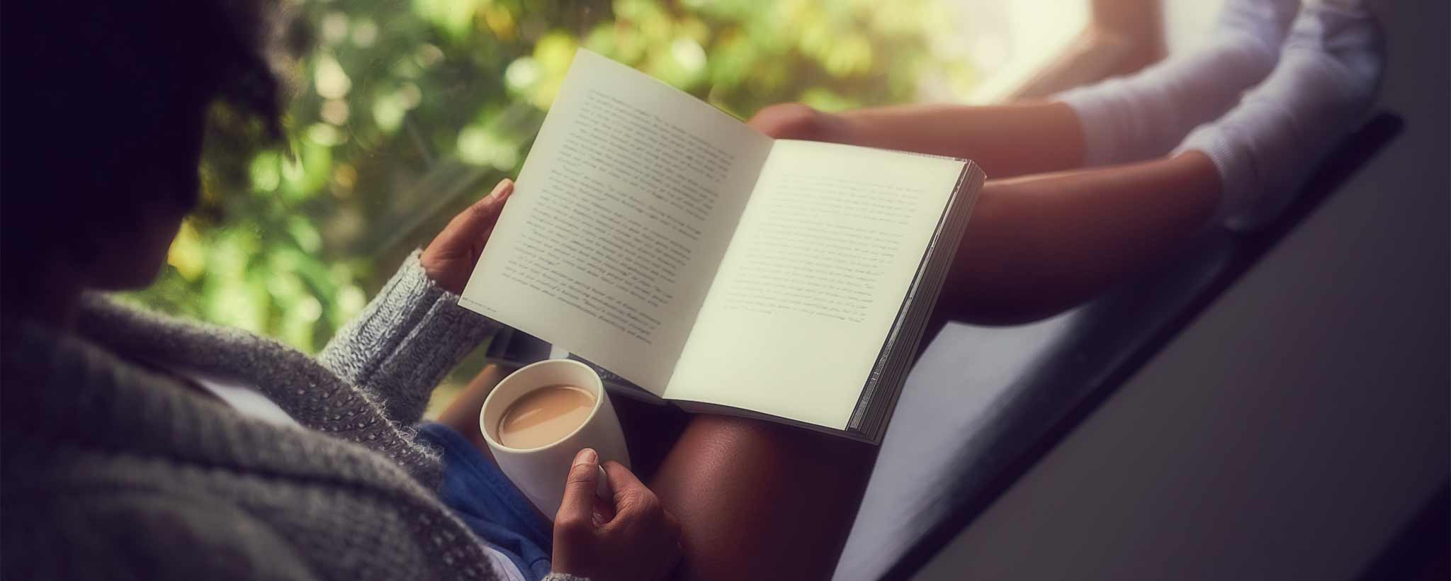 'Black woman reading book with coffee'