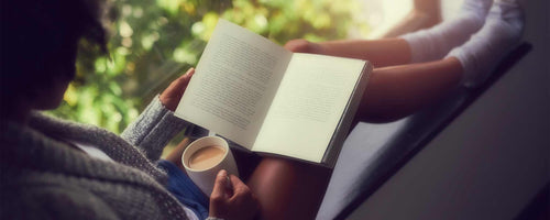 Black woman reading book with coffee