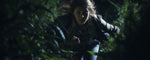 A blonde female is running through a dark forest. (ai)