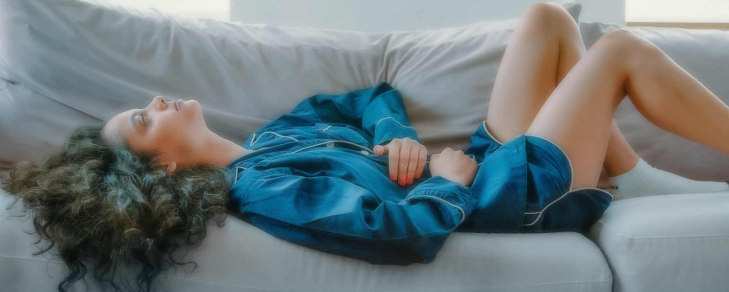 Woman lying on couch with early signs and symptoms of celiac disease