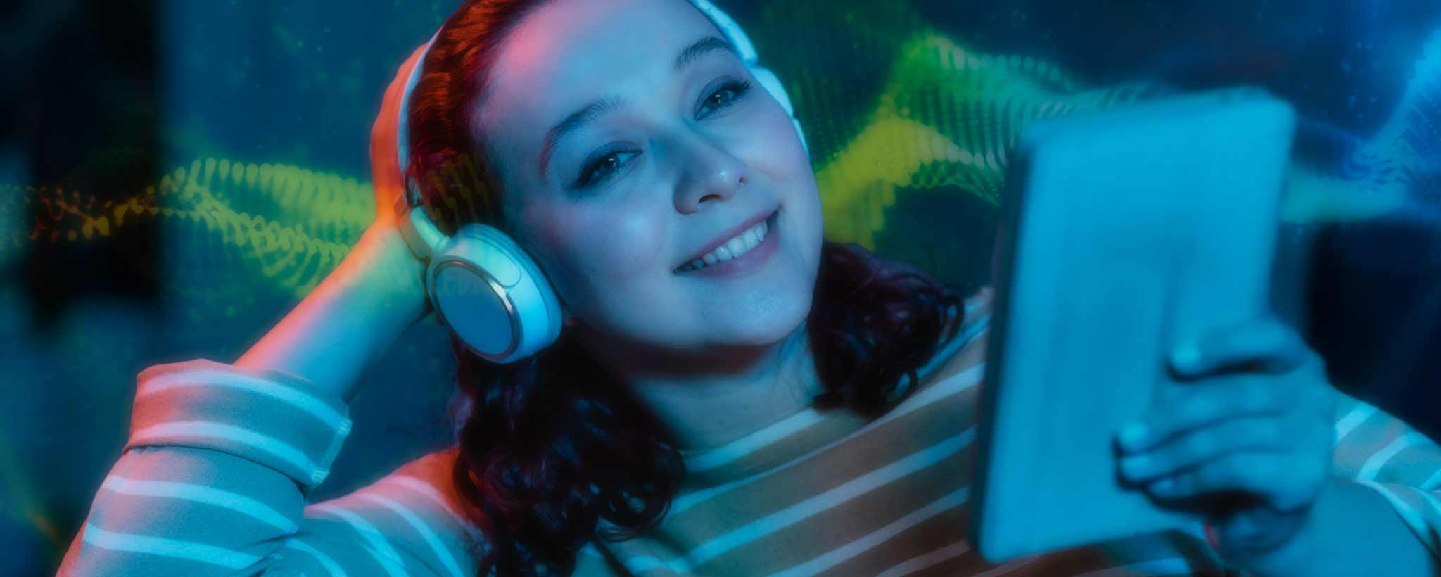 'Female with headphones enjoys tablet'