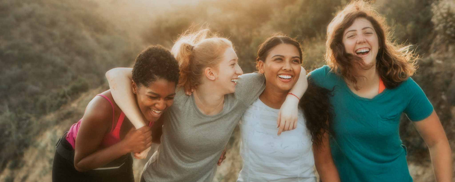 Four smiling women hiking in hills