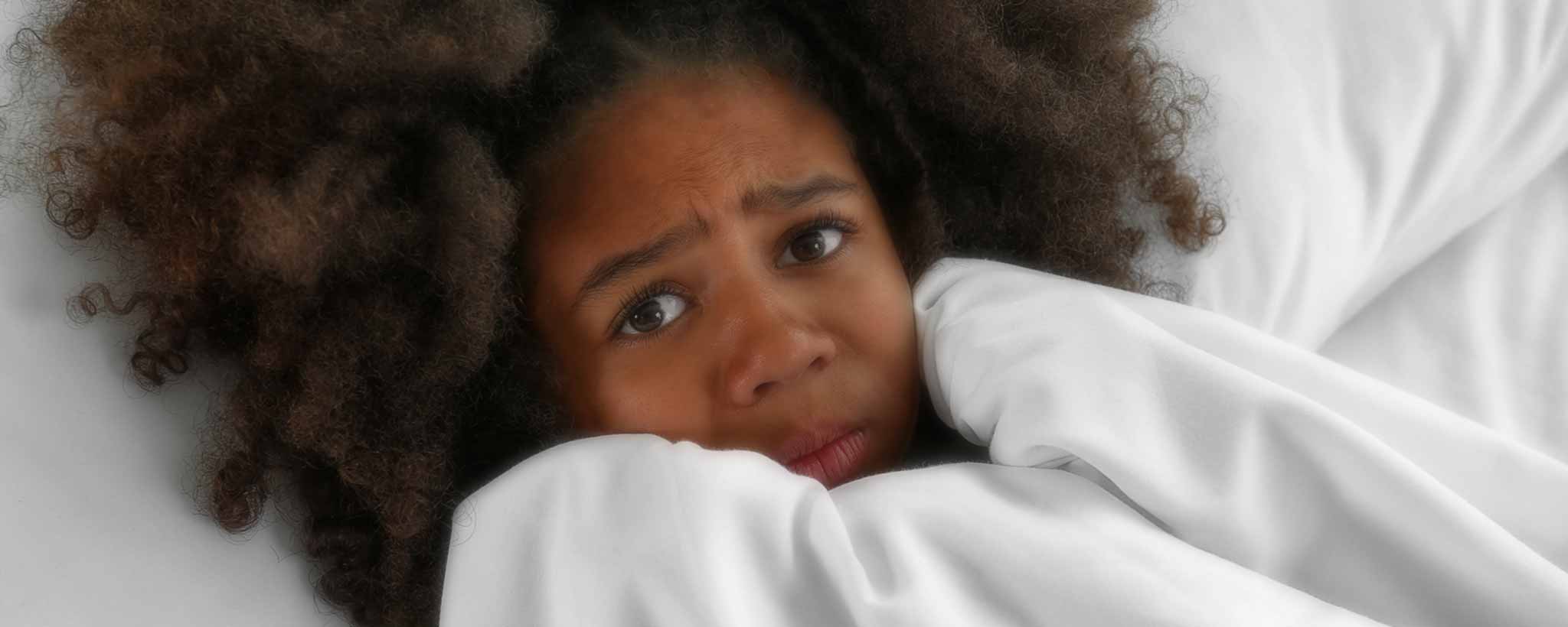 'Frightened black girl beneath sheets'