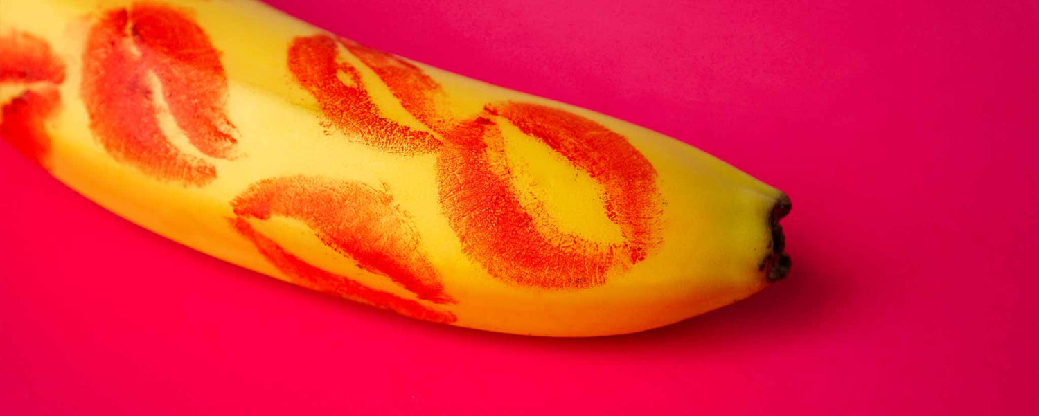 Red lipstick kisses on yellow banana