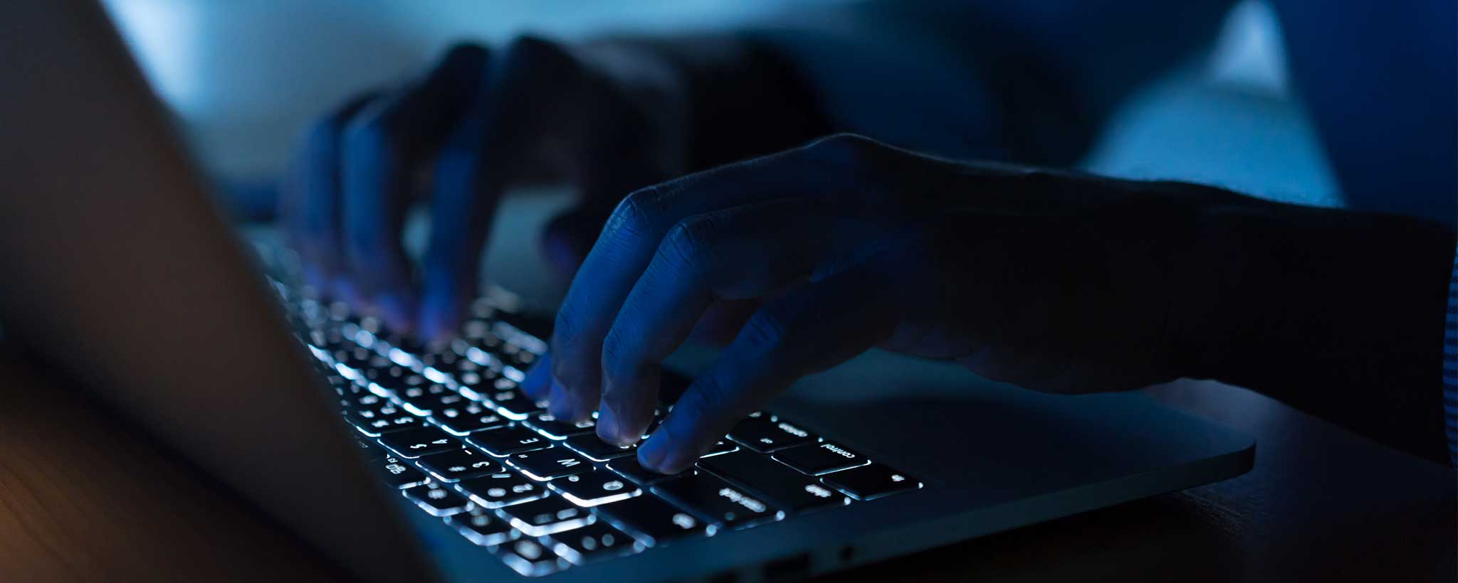 'Hands typing on dark keyboard'