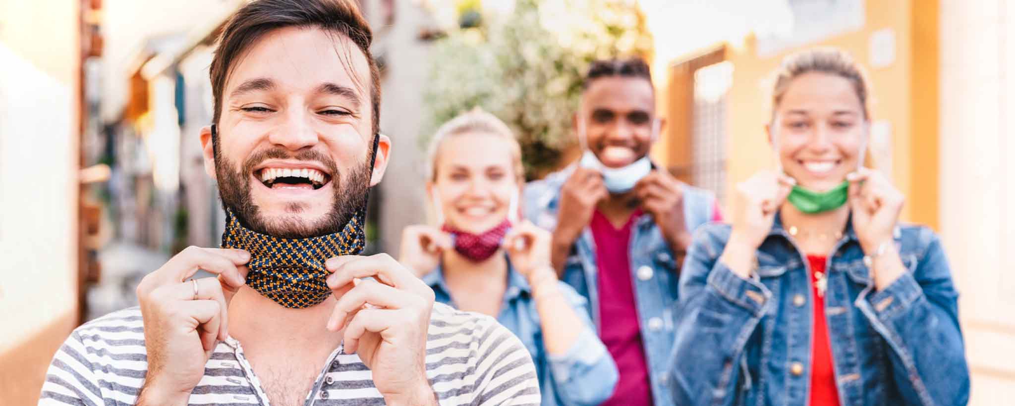 'Four people lowering face masks'