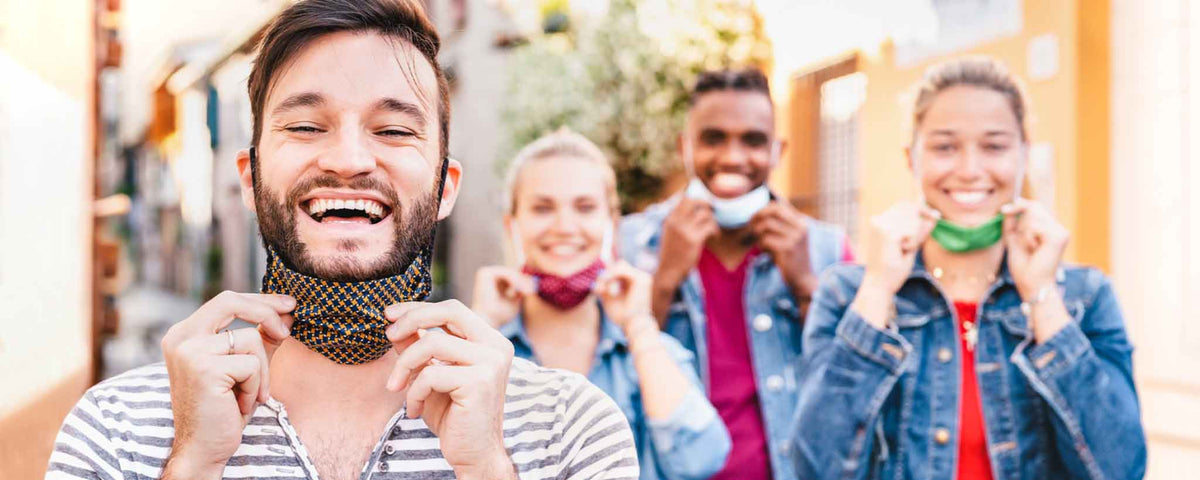 Four people lowering face masks
