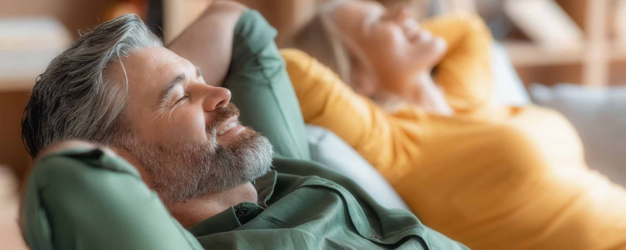 'Mature male and female smiling while resting'